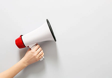 Hand hält Rot-Weißes Megafon in der Hand